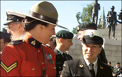 Un membre de la Gendarmerie royale du Canada et un membre des Forces canadiennes préparent les Médailles canadiennes du maintien de la paix à présenter